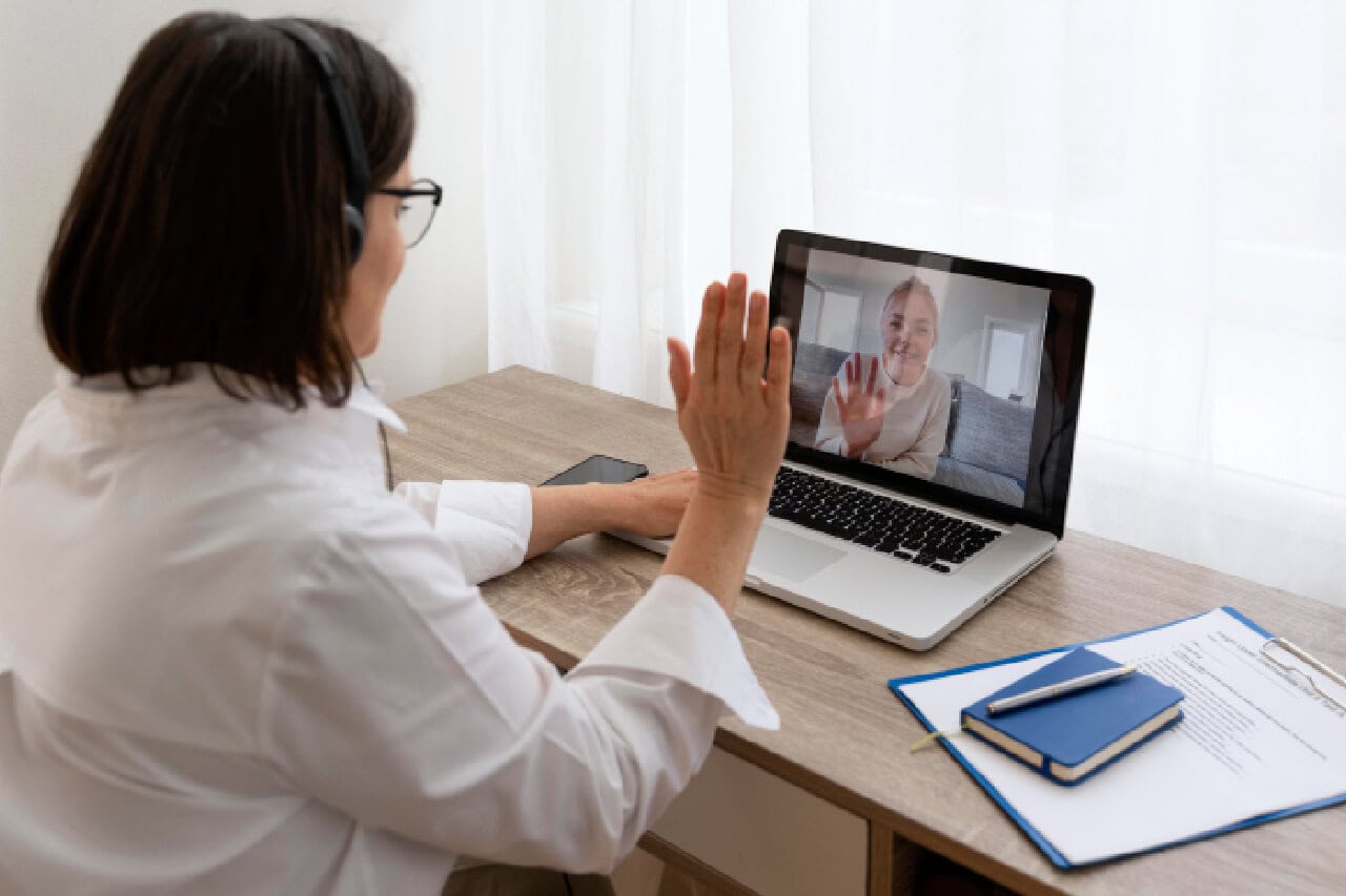Professional woman engaging in virtual consultation with elderly client via video call, telehealth service for senior care or medical support, remote healthcare counseling on laptop, healthcare technology, telemedicine, remote patient support.